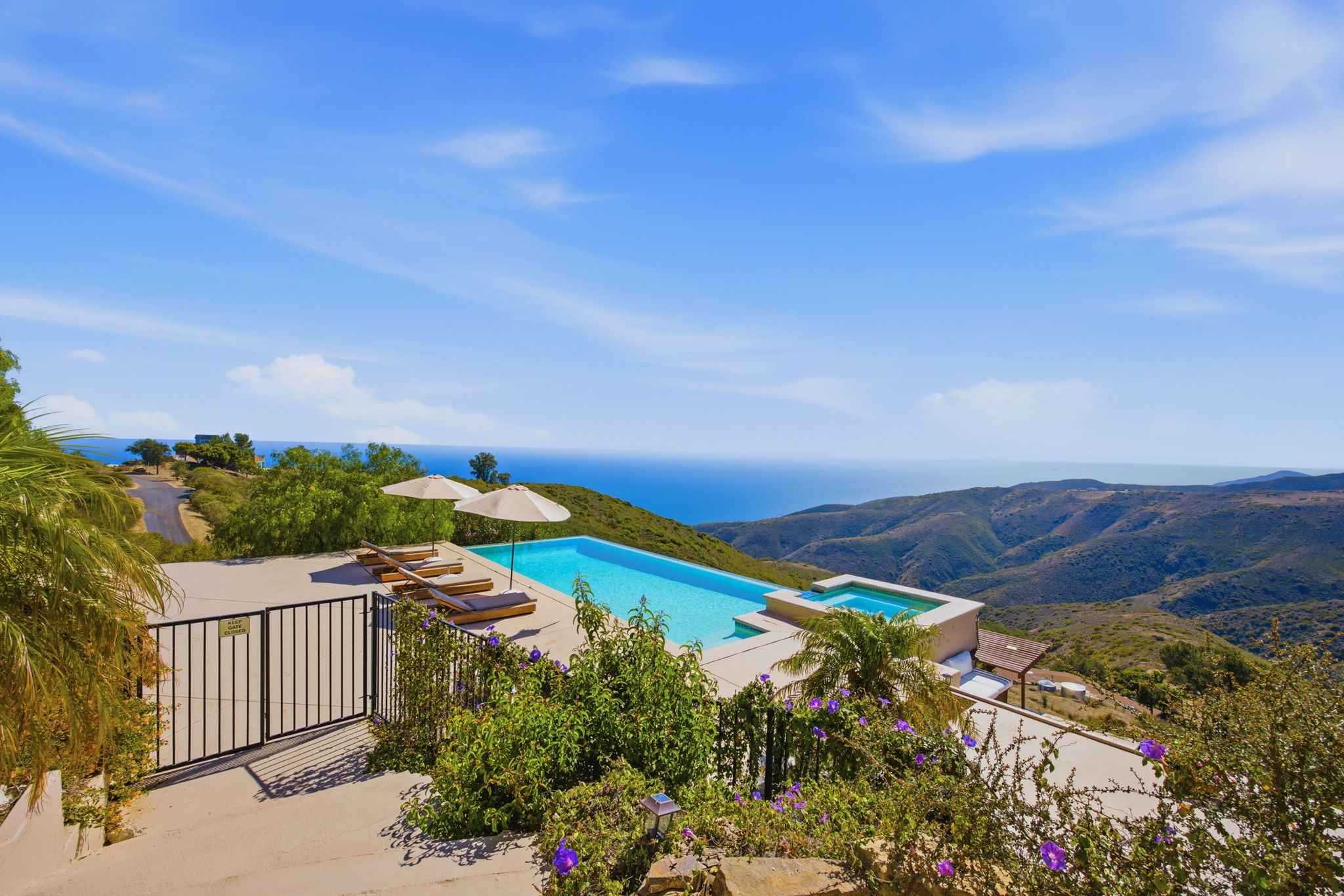 Pool terrace with umbrellas overlooking canyon ridgelines and the Pacific horizon