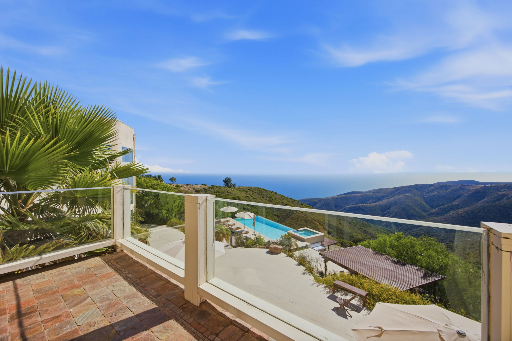 Glass-railed balcony above the pool terrace, looking across the canyons to the ocean